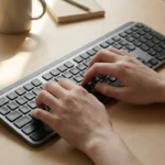 Overhead view of hands on keyboard with fingers flexing showing difficulty typing with neuropathy