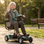 Older woman riding a four-wheel mobility scooter confidently on a neighborhood sidewalk in warm morning light.
