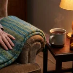 Generic pain reliever bottle beside a mug of tea on a warmly lit table