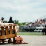 Woman seated in a chair with a back at an outdoor graduation.
